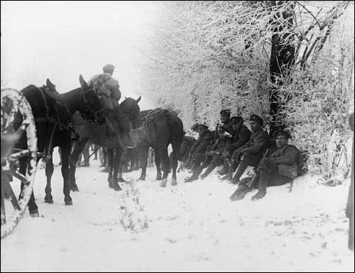 Des hommes du Newfoundland Regiment et un chariot tiré par des chevaux se reposent au bord de la route, dans la neige, près de Hesdin, le 20 décembre  1917