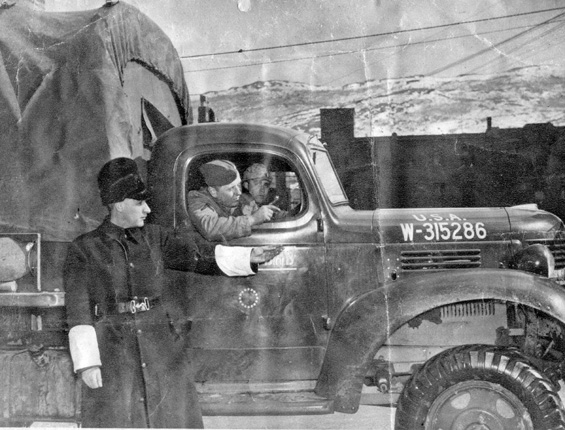 A constable directs the driver of an American truck, 1941